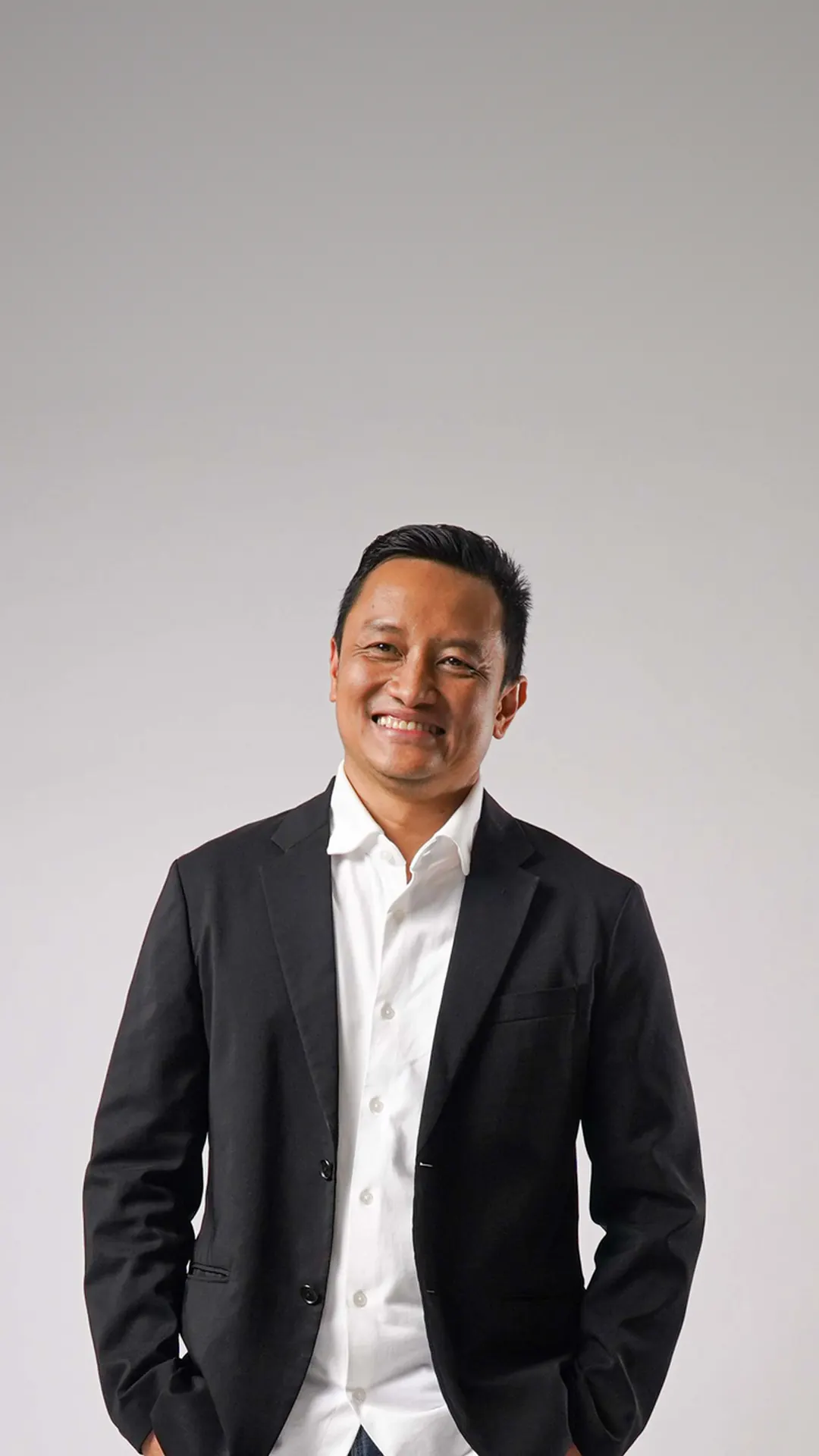 Herwin Muchtar berjas hitam, berdiri